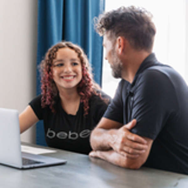 An adoptive dad sits at a table with his teen daughter